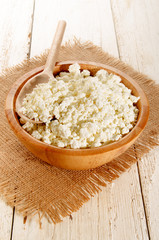home made cottage cheese with wooden spoon in a wooden bowl