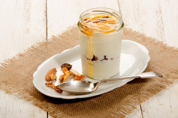 kefir in a glass with sweet honey, nuts and fruit