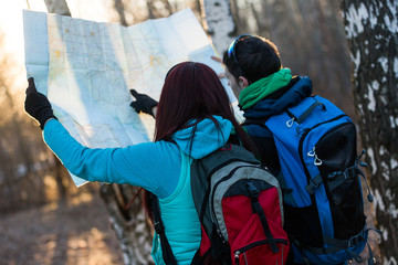 Fototapeta na wymiar Young couple hikers looking at map.