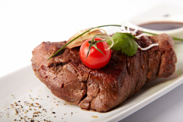 Whole peace of grilled meat with pear on a white background