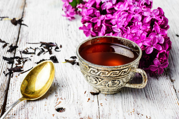 Still life with tea and branch of lilac