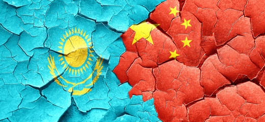 Kazakhstan flag with China flag on a grunge cracked wall