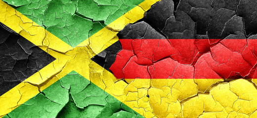 Jamaica flag with Germany flag on a grunge cracked wall