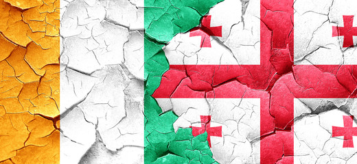 Ivory coast flag with Georgia flag on a grunge cracked wall