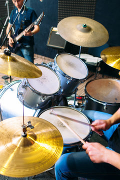 Unrecognizable drummer plays on drum set alive close-up. Front view on modern drum set and playing on it alive drummers hands. Scene background