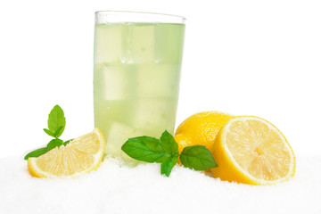Glass of lemon juice,ice cubes on snow on white