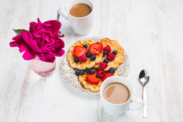 Junge Frau frühstückt und trinkt Kaffee