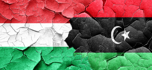Hungary flag with Libya flag on a grunge cracked wall