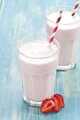 Strawberry milkshake glasses and strawberry slices.