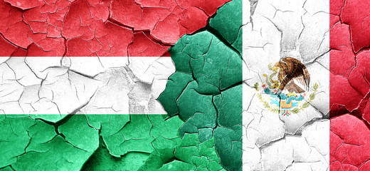 Hungary flag with Mexico flag on a grunge cracked wall