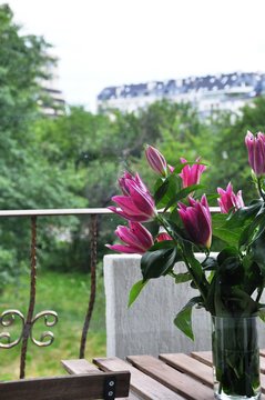 Purple Liliums in a vase on a balcony