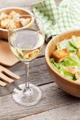 Fototapeta na wymiar White wine glass and caesar salad