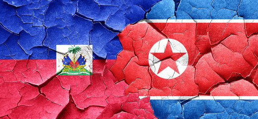 Haiti flag with North Korea flag on a grunge cracked wall