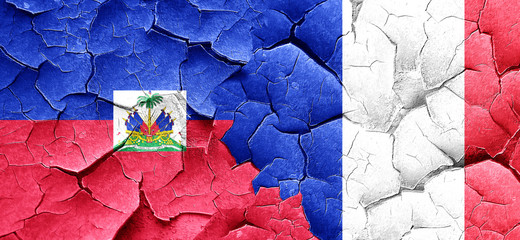 Haiti flag with France flag on a grunge cracked wall