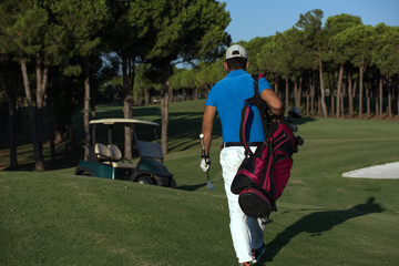 Obraz premium golfer walking and carrying golf bag