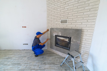 Fireplace installing in white brick wall