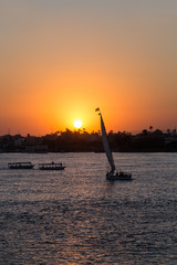 Tourist sailboat at Luxor waterfront during sunset.
