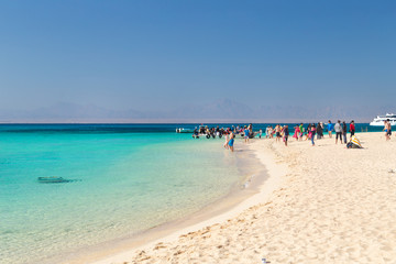 PARADISE ISLAND, EGYPT - FEBRUARY 12, 2016: Tourists at the beach taking of the boats.