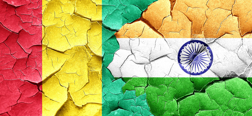 Guinea flag with India flag on a grunge cracked wall