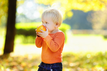 Toddler boy eating fresh bio peach