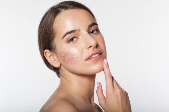 Beautiful girl with suncreen cream on skin