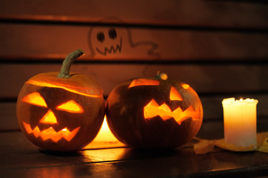 Halloween pumpkin head jack lantern with paint of ghost on background