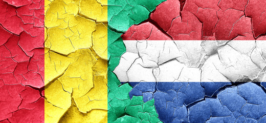 Guinea flag with Netherlands flag on a grunge cracked wall