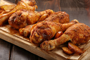 Roasted chicken legs on wooden background
