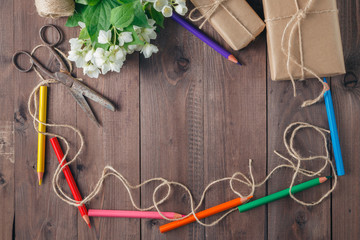 pen and flowers over wooden background. Top view with copy space