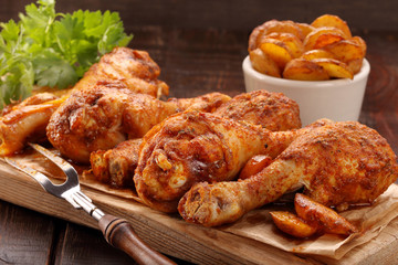 Roasted chicken legs with potato chips and vegetables