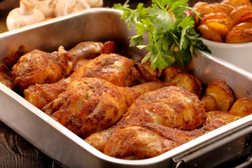 Roasted chicken legs with potato chips and vegetables