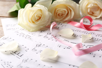Naklejka premium Beautiful rose on music sheets background