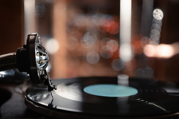 Fototapeta na wymiar Turntable with vinyl record on dark blurred background