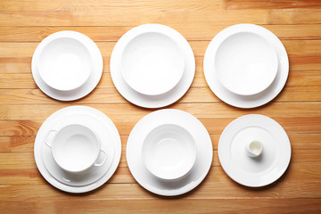 Set of white dishes on wooden background