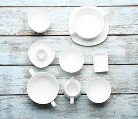 Set of white dishes on wooden background