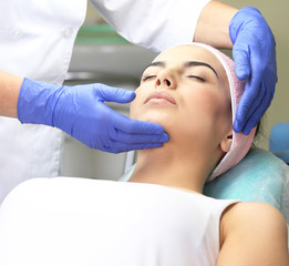 Fototapeta na wymiar Young woman having face massage in a beauty salon