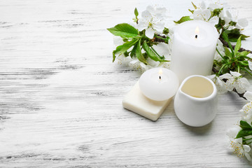 Spa treatment with blooming branch on white wooden table