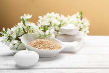 Spa treatment with blooming branch on white wooden table