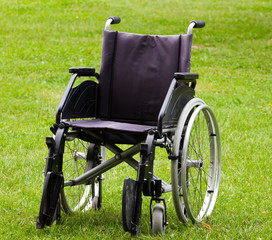 Fototapeta na wymiar Empty wheelchair on grass field