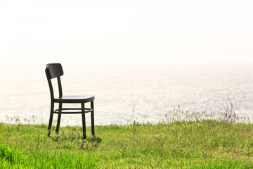 Black chair on the hill by the sea