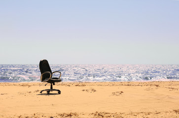 Fototapeta na wymiar An office chair on the beach
