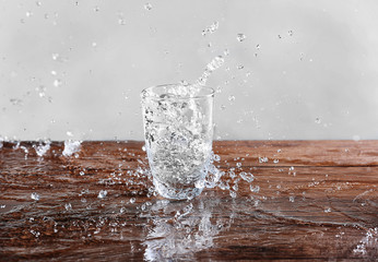 Pouring water into glass on wooden table