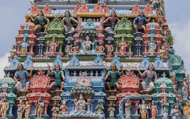 Chettinad, India - October 17, 2013:Detail of the Shiva temple gopuram at Kottaiyur shows twice Shiva as supreme teacher known as Dakshinamurthy. Plenty of colorful statues.