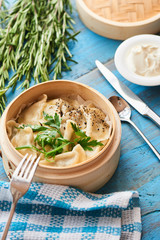 Breakfast homemade ravioli in a wooden pot and rustic cream on the table