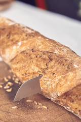 baguette bread on wooden cutting board - slicing