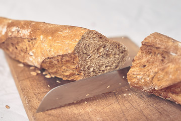  baguette bread on wooden cutting board - flying crumbs