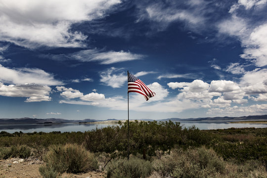 American flag waving against a cloudy sky