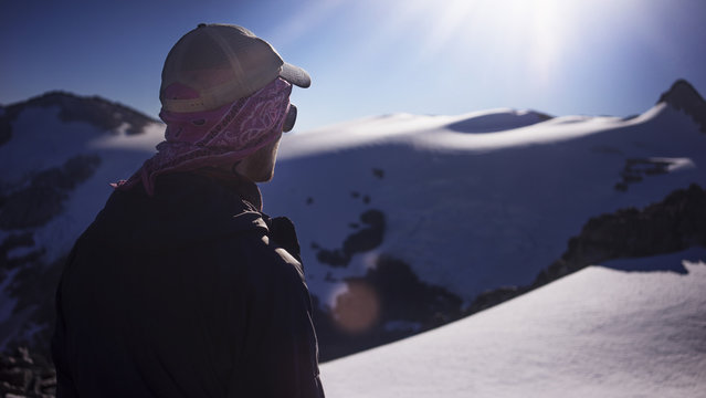 Man standing at snow covered field on sunny day