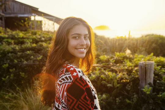 Portrait of young girl at sunset by beach house
