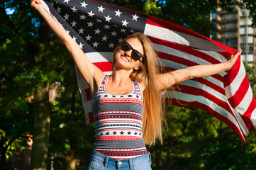 Young happy patriot woman holding the united states flag